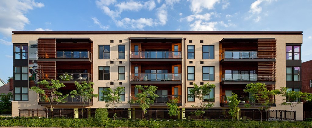 a row of apartment buildings with trees in front of them