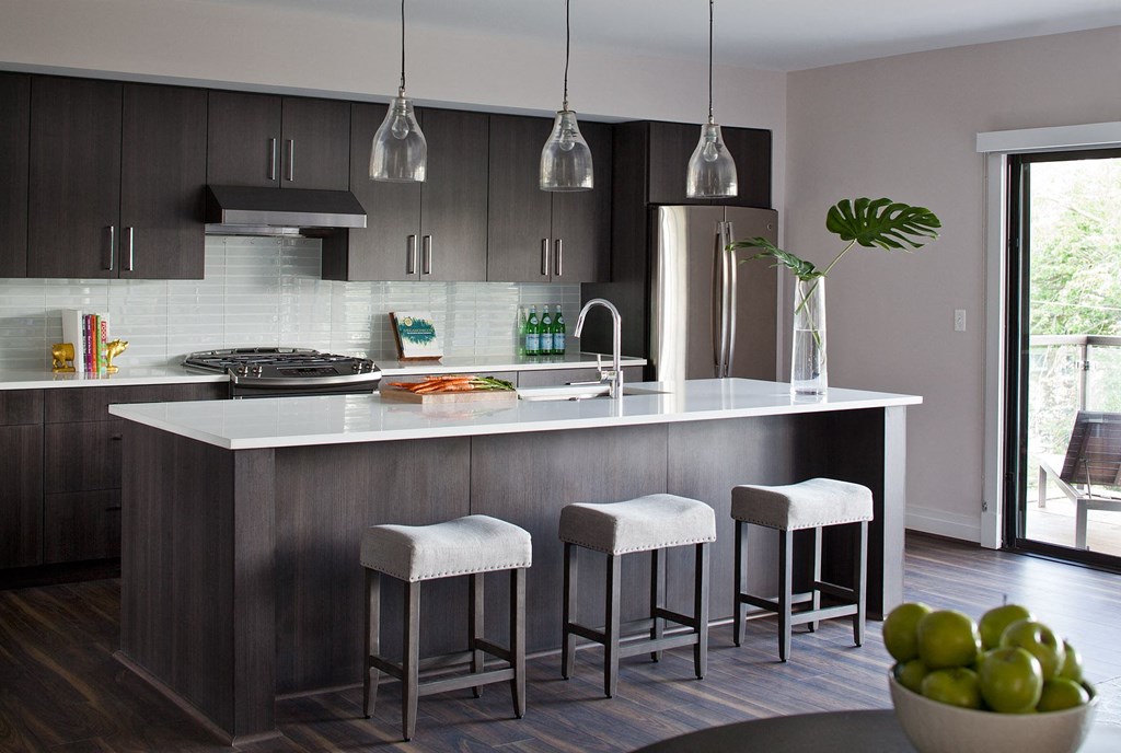 a kitchen with an island and three stools in it