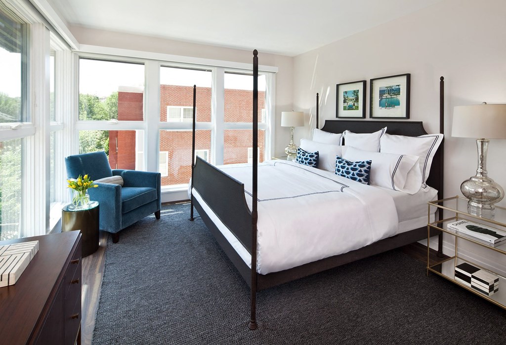 a bedroom with a bed and a large window