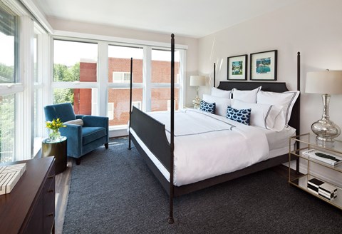 a bedroom with a bed and a large window