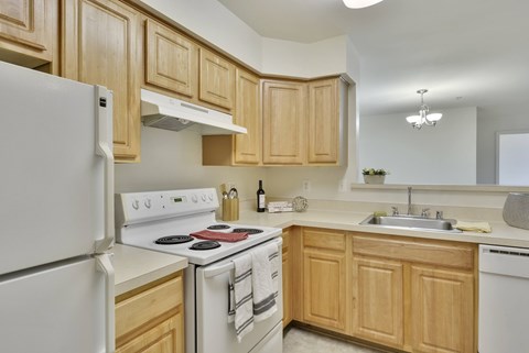 A kitchen with wooden cabinets and white appliances.