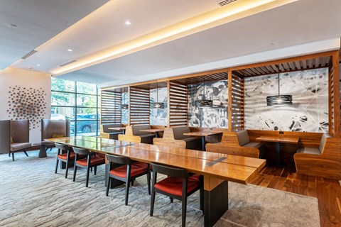 A modern dining room with a long table and chairs.