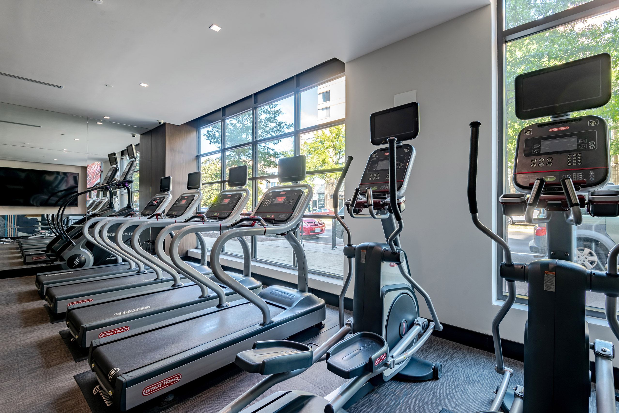 A gym with treadmills and elliptical machines.