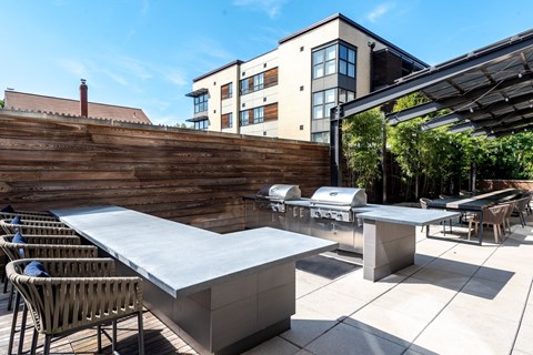 A modern outdoor dining area with a long table and chairs.