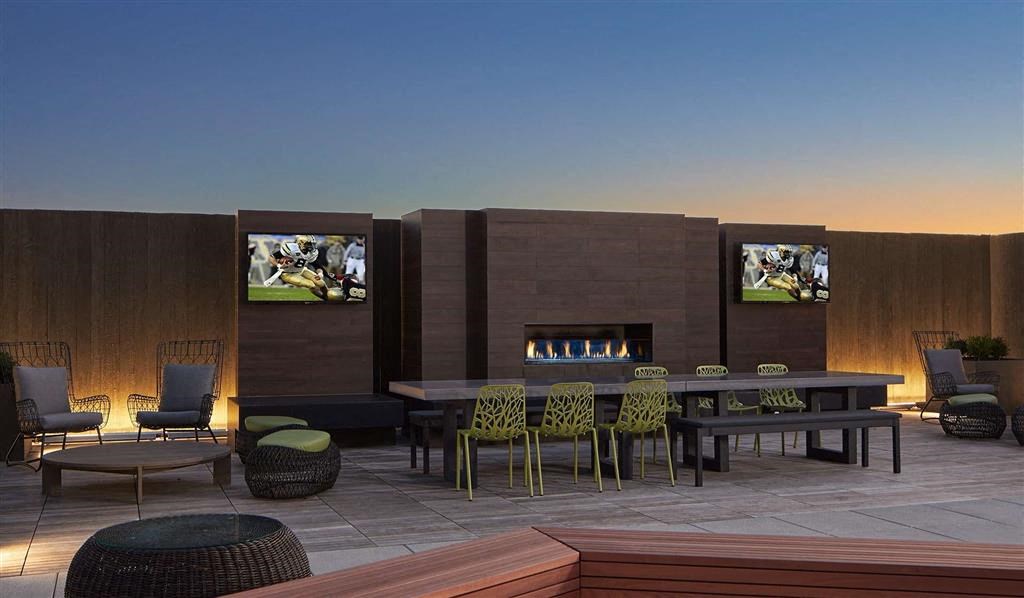 a patio with a table and chairs and a fireplace