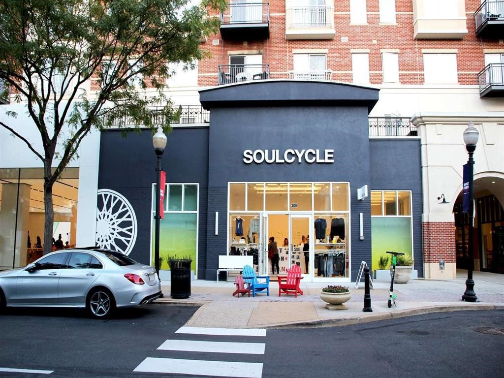 a store on the corner of a street with a car