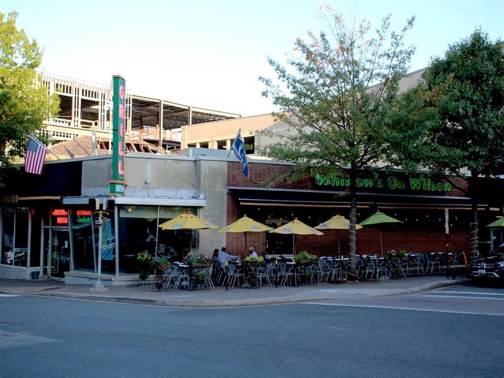 a restaurant on the corner of a street with tables and umbrellas