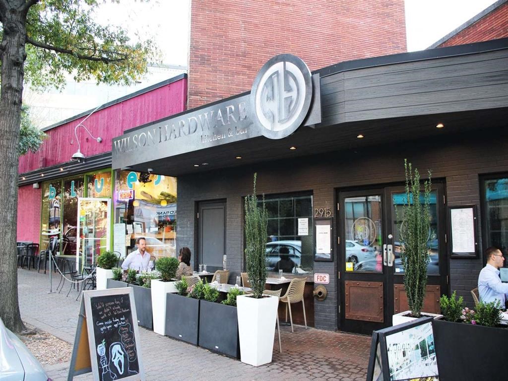 the front of a restaurant with people sitting at tables