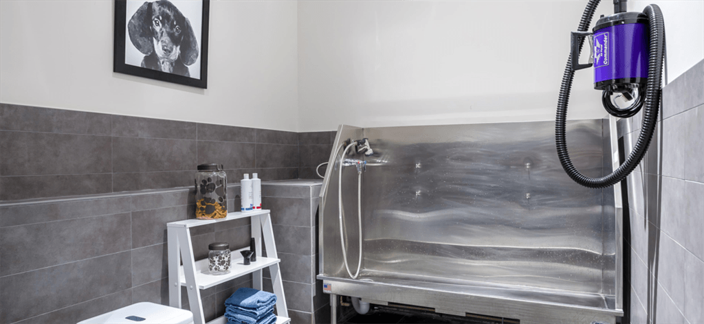 a small bathroom with a shower and a silver tub