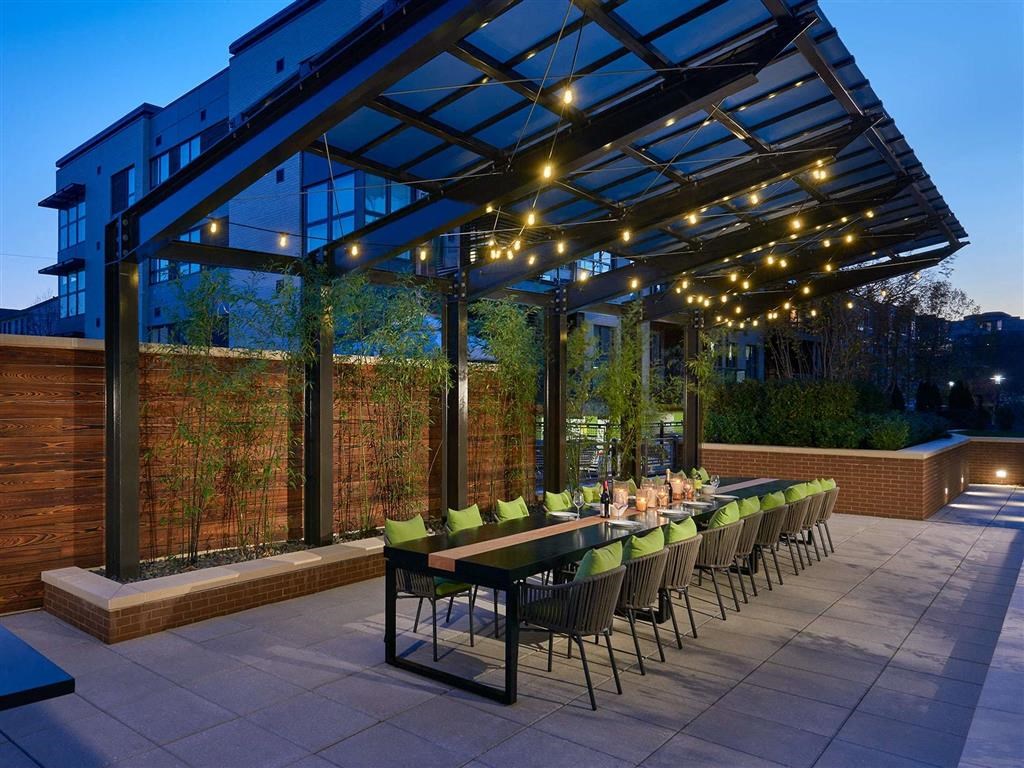 a long table and chairs under a large roof with lights