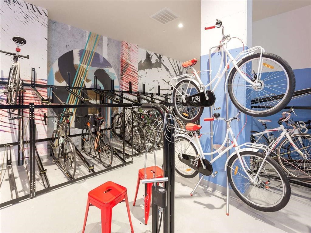 a display of bicycles on a rack in a room with red stools