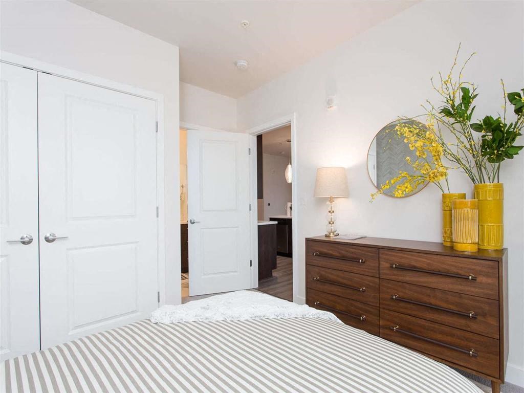 a bedroom with a bed and a dresser with a mirror