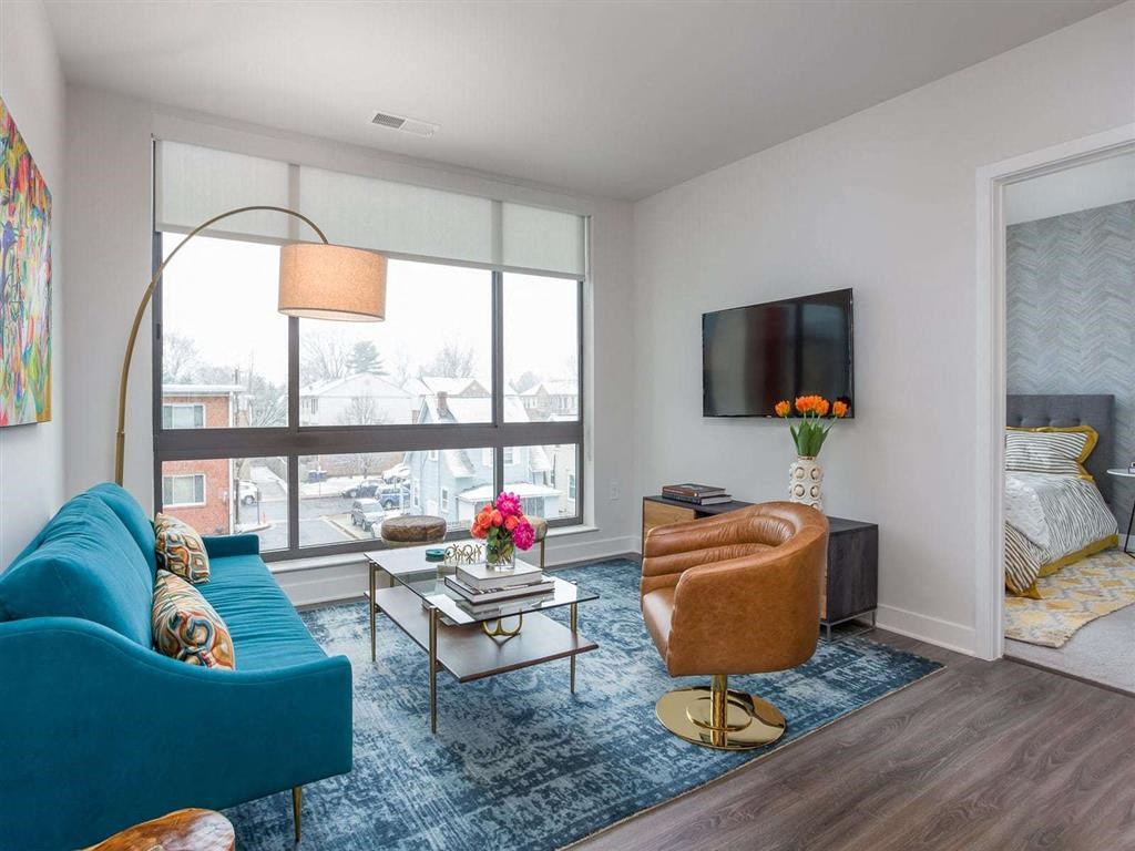 a living room with a large window and a blue couch