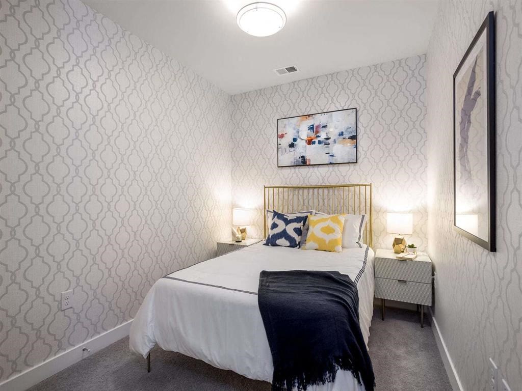 a bedroom with a white bed and a white wallpaper