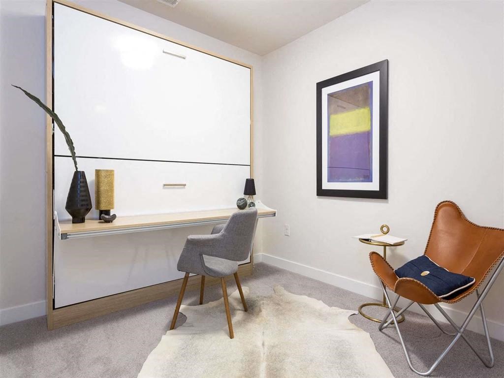 a room with a chair and a desk and a mirror