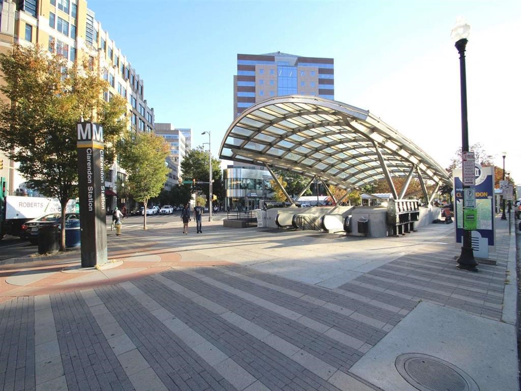 a bridge over a street in a city with tall buildings