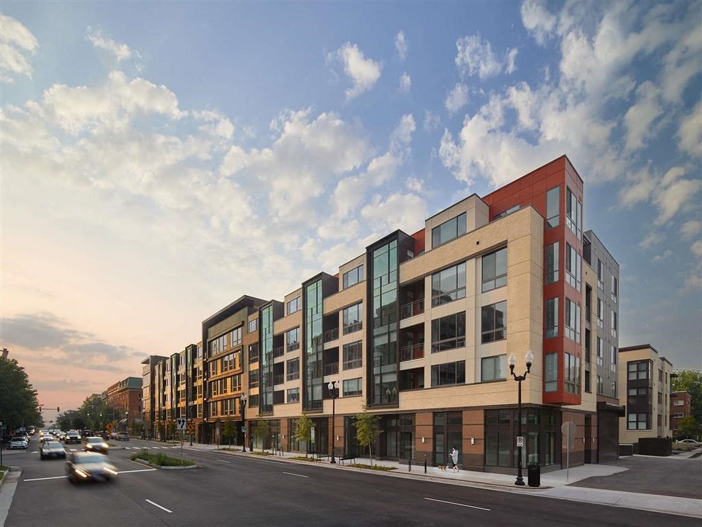 a rendering of a new apartment building on a city street