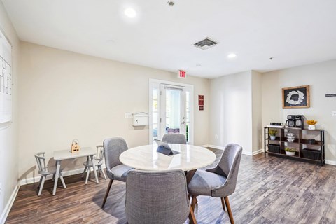 Community lounge with round dining table at Potomac Station Apartments, Leesburg, Virginia