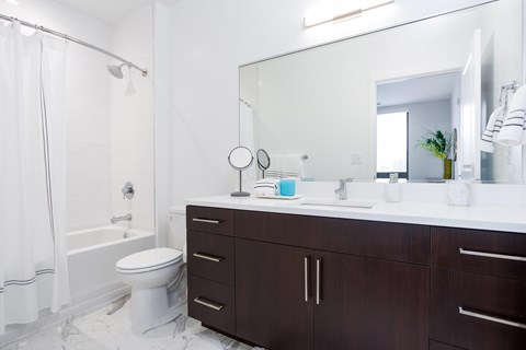 A white bathroom with a toilet, sink, and mirror.