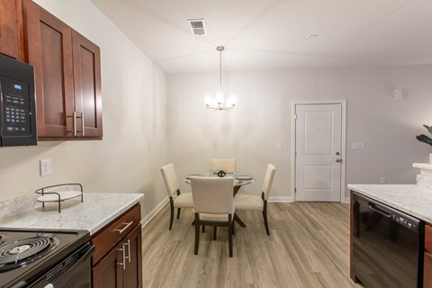 A kitchen with a table and chairs.