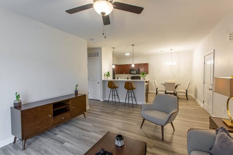 A living room with a grey chair and a wooden cabinet.