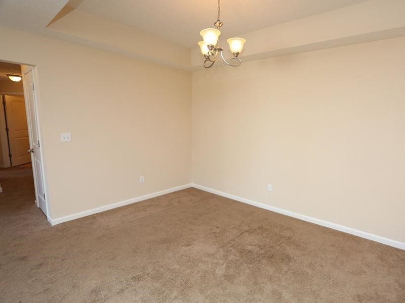 an empty living room with beige walls and carpet