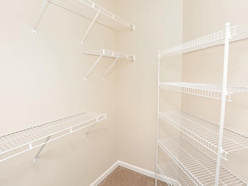 an empty closet with empty shelves in a white room