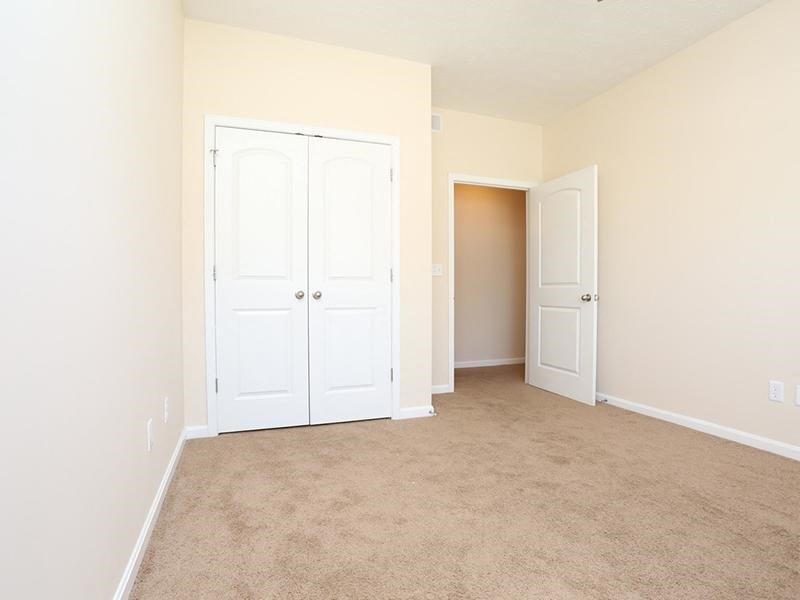 an empty room with two doors and a carpeted floor
