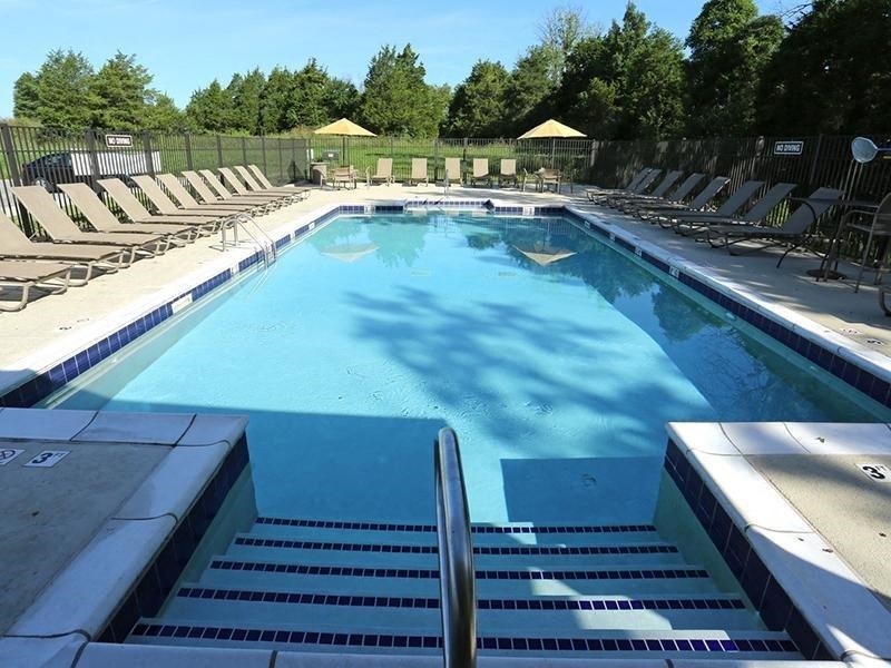 a large swimming pool with chairs around it