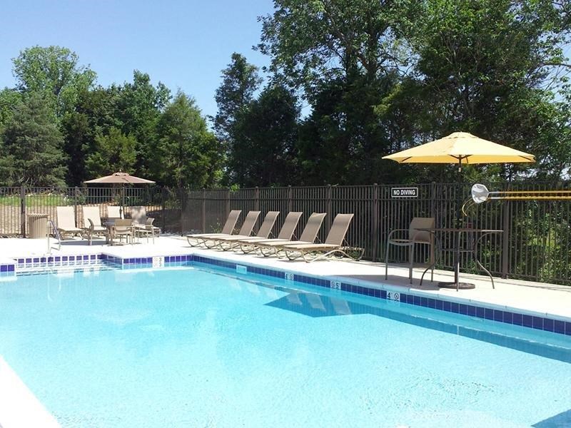 a swimming pool with chairs and an umbrella