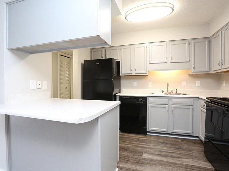 a kitchen with white cabinets and a black refrigerator