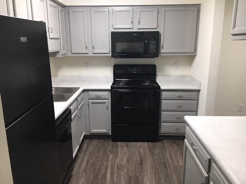 a kitchen with black appliances and white cabinets