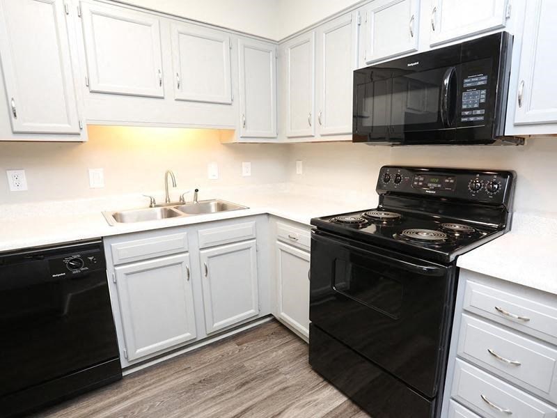 a kitchen with black appliances and white cabinets