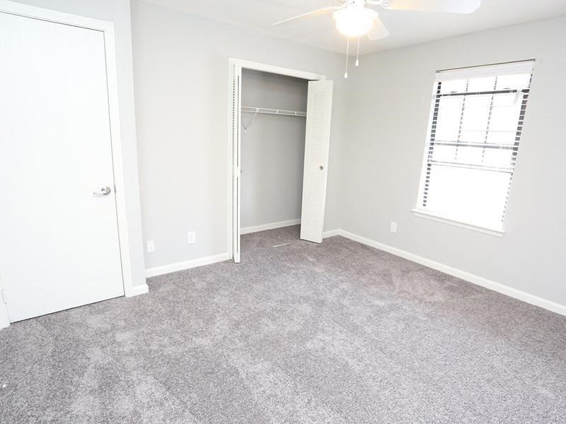 an empty room with carpet and a closet