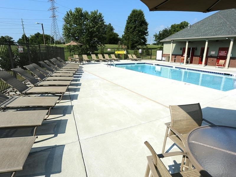 a swimming pool with chairs and tables around it