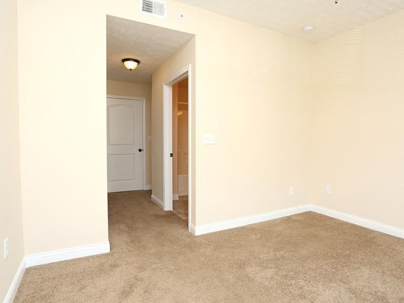 an empty living room with a door to a hallway