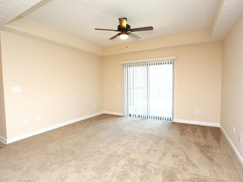 an empty living room with a ceiling fan