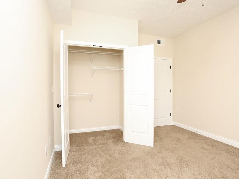 an empty bedroom with a closet and an open door
