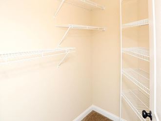 a walk in closet with empty empty shelves