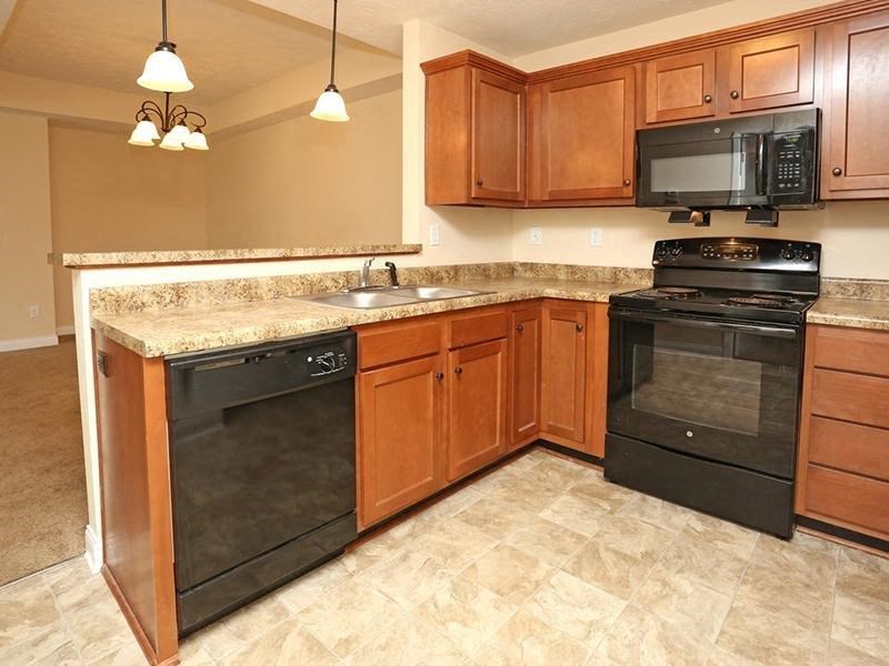 a kitchen with black appliances and wooden cabinets