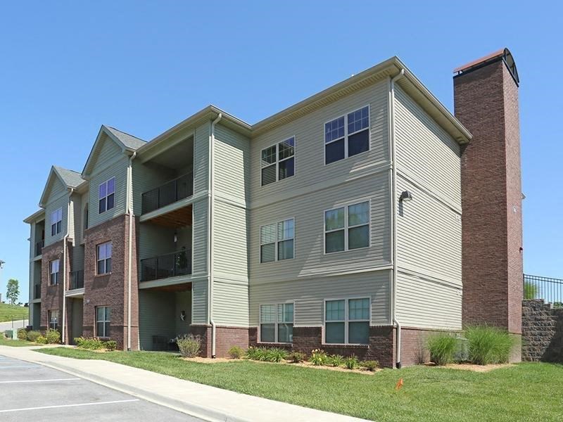 an apartment building with brick and tan siding