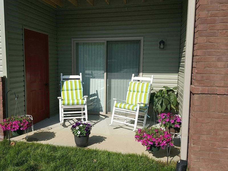 two rocking chairs on the porch of a house