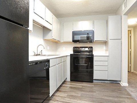 a kitchen with black appliances and white cabinets