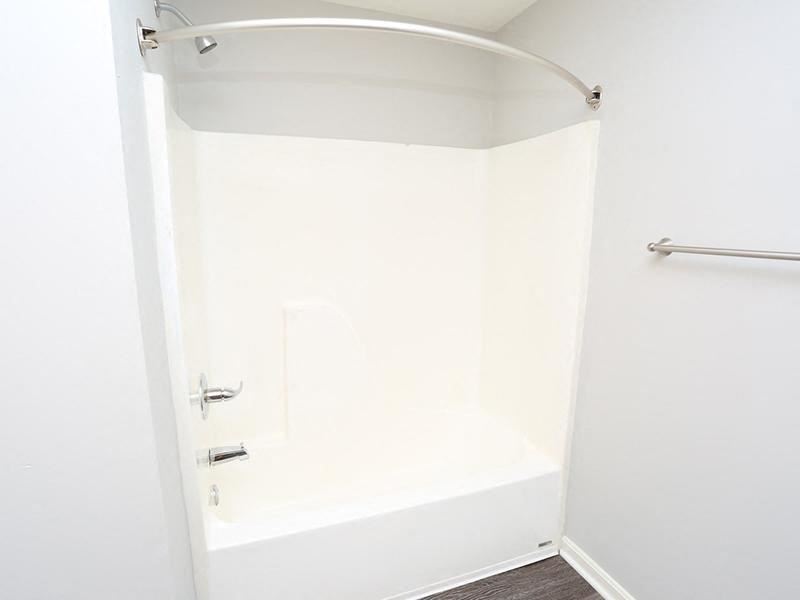 a white bathroom with a shower and a towel rack
