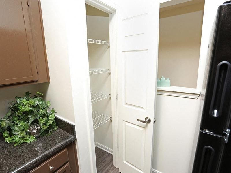 a kitchen with white cabinets and an open closet