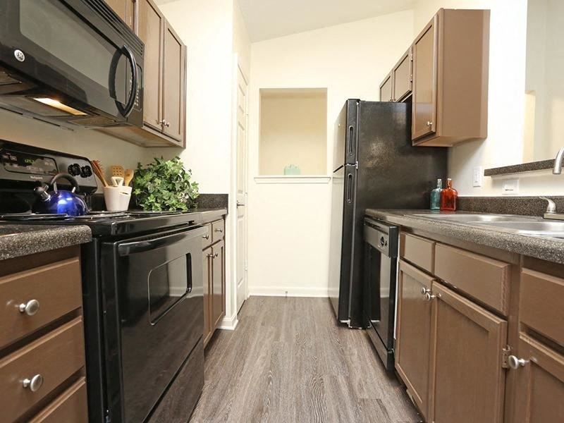 a kitchen with black appliances and wooden cabinets