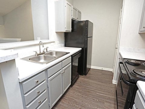 a kitchen with a sink and a black refrigerator