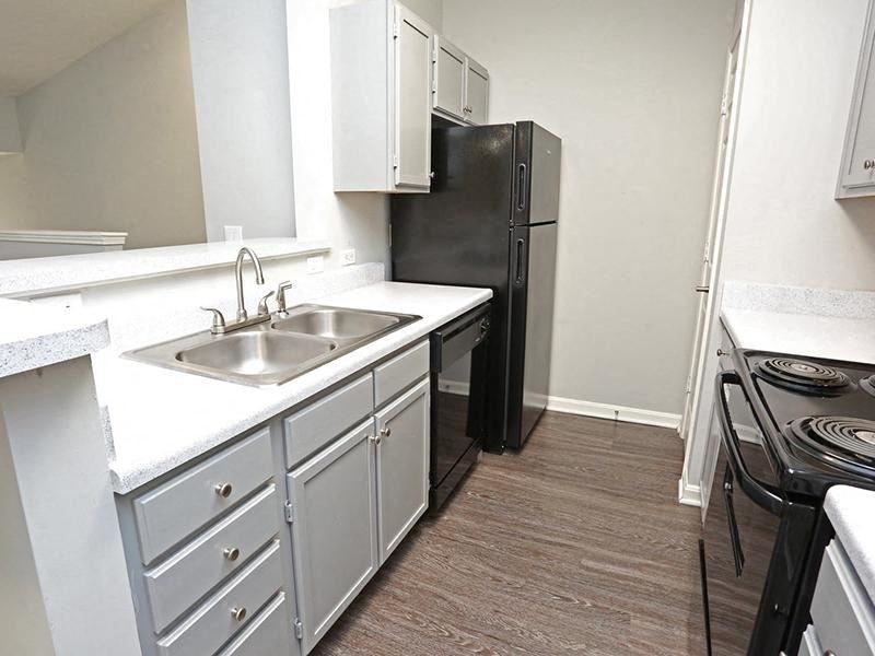 a kitchen with a sink and a black refrigerator