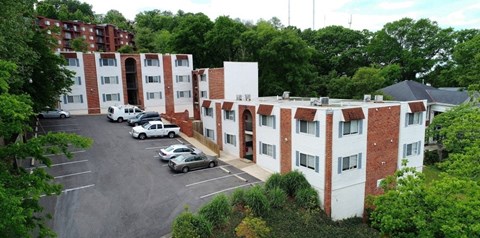 A parking lot in front of a red and white building.