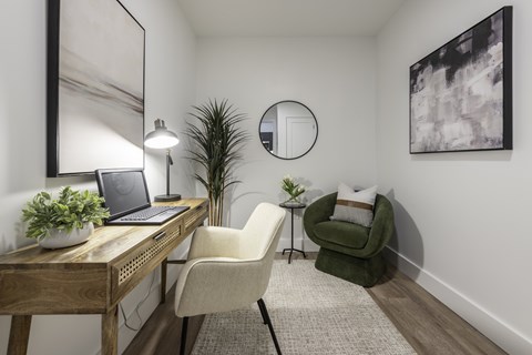 A room with a desk, chair, and a mirror.